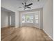 Inviting living room with wood floors, a ceiling fan, a bay window, and lots of natural light at 2018 Rockycreek Ln, Monroe, NC 28112