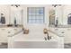 Relaxing bathroom featuring a soaking tub with double vanities and granite countertops at 214 Blossom Ridge Dr, Mooresville, NC 28117