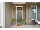 Inviting front door with wreath, ferns, and stylish brick facade creates a warm entrance at 220 Forsythia Ln, Tega Cay, SC 29708