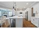 Bright, open kitchen featuring a large island, white cabinetry, and hardwood floors at 220 Forsythia Ln, Tega Cay, SC 29708