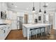 Well-lit kitchen with white cabinets, stainless steel appliances, large center island, and hardwood floors at 220 Forsythia Ln, Tega Cay, SC 29708