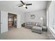 Bright living room with a ceiling fan, a gray sofa with decorative pillows and neutral walls at 220 Forsythia Ln, Tega Cay, SC 29708