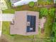 Aerial view of a home with solar panels, a driveway, and a backyard fire pit at 2306 Nettleton Ct, Matthews, NC 28105