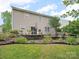 Beautiful backyard features a stone patio with dining area and a multi-tiered flower bed at 2306 Nettleton Ct, Matthews, NC 28105