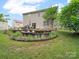 Landscaped backyard showing a stone fire pit, dining table, and sliding door leading to the home's interior at 2306 Nettleton Ct, Matthews, NC 28105