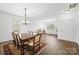 Elegant dining room with an ornate table, chandelier, and hardwood floors bathed in natural light at 2306 Nettleton Ct, Matthews, NC 28105