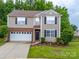 Traditional two-story home featuring a two-car garage, neutral siding, and neatly landscaped front yard at 2306 Nettleton Ct, Matthews, NC 28105