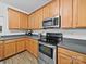 Modern kitchen featuring stainless steel appliances, wooden cabinets, and gray countertops at 2306 Nettleton Ct, Matthews, NC 28105