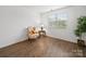 Cozy living room featuring hardwood floors, a comfortable armchair, and natural light from a large window at 2306 Nettleton Ct, Matthews, NC 28105
