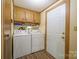 This spacious laundry room features wood cabinets above appliances and exterior access at 2310 Alexis Lucia Rd, Stanley, NC 28164