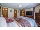 Main bedroom with attached en suite bath featuring a four poster bed and view of the kitchen at 2310 Alexis Lucia Rd, Stanley, NC 28164