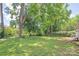 Spacious backyard featuring mature trees and lush green grass, providing a private outdoor retreat at 2409 Thornton Rd, Charlotte, NC 28208