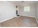 Bright bedroom features neutral walls, trim and wood grain flooring, with a window and a stairway at 2409 Thornton Rd, Charlotte, NC 28208