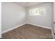 Cozy bedroom with new floors, a bright window, and neutral paint at 2409 Thornton Rd, Charlotte, NC 28208