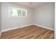 Comfortable bedroom with wood-look flooring, a window, and fresh paint at 2409 Thornton Rd, Charlotte, NC 28208