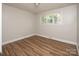 Serene bedroom featuring new flooring, a bright window, and clean white walls at 2409 Thornton Rd, Charlotte, NC 28208