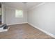 Bright bedroom has neutral walls, trim and wood grain flooring, and exterior access via steps at 2409 Thornton Rd, Charlotte, NC 28208