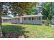 Inviting single-story home with gray siding, trimmed windows, and a lush front lawn at 2409 Thornton Rd, Charlotte, NC 28208