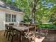 Backyard patio with outdoor dining and grilling area, shaded by mature trees at 2410 Vernon Dr, Charlotte, NC 28211