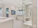 Bright bathroom featuring a walk-in shower, soaking tub and white marble floors at 2410 Vernon Dr, Charlotte, NC 28211