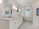 Bright bathroom features double sinks, marble counters, custom cabinets, and tile floors at 2410 Vernon Dr, Charlotte, NC 28211