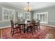 Dining room featuring an oval table, six chairs, a chandelier, and three windows with natural light at 2410 Vernon Dr, Charlotte, NC 28211