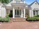 Close-up of the home's entrance with brick steps, white columns, and light blue door with glass panels at 2410 Vernon Dr, Charlotte, NC 28211