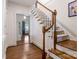 Hallway and staircase with hardwood floors and carpeted steps, creating a warm and inviting entrance at 2410 Vernon Dr, Charlotte, NC 28211