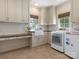 Bright laundry room with built-in cabinets, utility sink, washer and dryer at 2410 Vernon Dr, Charlotte, NC 28211