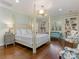 Bright main bedroom features a four-poster bed, hardwood floors, and natural light at 2410 Vernon Dr, Charlotte, NC 28211