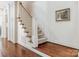 Staircase with wooden handrail and carpeted steps, complemented by hardwood floors and painted walls at 2410 Vernon Dr, Charlotte, NC 28211