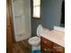 Cozy bathroom with a shower, wooden vanity, and charming blue wallpaper at 2583 Robinson Rd, Newton, NC 28658