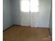 Compact bedroom with light blue walls, patterned curtains, and carpet flooring at 2583 Robinson Rd, Newton, NC 28658