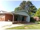 Home exterior featuring a covered side entrance, brick accents, and manicured landscaping at 2583 Robinson Rd, Newton, NC 28658