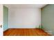 A room with unpainted walls, hardwood floors, and a white-painted brick wall at 2645 Kool Park Ne Rd, Hickory, NC 28601