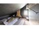 A dark, unfinished attic room with a window, sloped ceiling, and exposed brick at 2645 Kool Park Ne Rd, Hickory, NC 28601