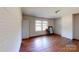 A white room with hardwood floors, a window, and a door leading to another room at 2645 Kool Park Ne Rd, Hickory, NC 28601