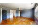 A blue-painted room with hardwood floors, a window, and doors leading to other rooms at 2645 Kool Park Ne Rd, Hickory, NC 28601