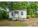 View of the home's exterior with a quaint porch, surrounded by lush green trees at 2905 Grimes St, Charlotte, NC 28206