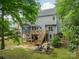 Spacious backyard featuring a screened porch, wooden deck, mature trees, and a cozy fire pit area for outdoor enjoyment at 2907 Notchview Ct, Charlotte, NC 28210