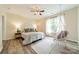 Cozy bedroom with hardwood floors, a ceiling fan, and a hanging macrame chair by the window at 2907 Notchview Ct, Charlotte, NC 28210