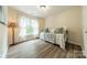 Guest bedroom with wood-look floors and a window with sheer curtains at 2907 Notchview Ct, Charlotte, NC 28210