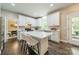 Bright kitchen featuring white cabinets, a white island, and seating for two at 2907 Notchview Ct, Charlotte, NC 28210