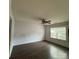 Bright living room with dark wood floors, fan, and a large window for ample natural light at 3012 Longspur Dr, Matthews, NC 28105