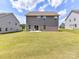 Expansive backyard featuring lush green grass with the home's exterior and neighboring houses visible at 3023 Ballester Rd, Fort Mill, SC 29707