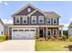 Charming two-story home boasts a well-manicured lawn, a two car garage, and beautiful landscaping at 3023 Ballester Rd, Fort Mill, SC 29707