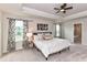 Serene main bedroom suite offers a tray ceiling, plush carpet, and natural light from the large windows at 3023 Ballester Rd, Fort Mill, SC 29707