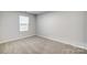 Neutral-toned bedroom featuring carpet, a window with blinds, and freshly painted walls at 3844 Cheyney Park Dr, Charlotte, NC 28269