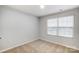 A simple bedroom featuring neutral paint, carpet, and a window with blinds, offering a blank canvas at 3844 Cheyney Park Dr, Charlotte, NC 28269