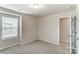 Cozy bedroom with neutral carpet, a window with blinds, and an adjoining doorway at 3936 Cheyney Park Dr, Charlotte, NC 28269